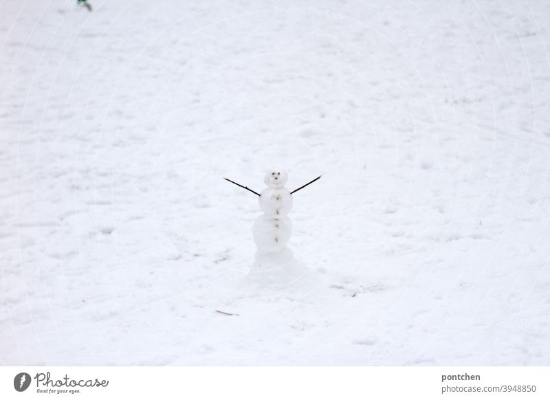 A little snowman stands in the snow with his arms outstretched. Winter Snowman Children's game Joy White Cold Playing Nature Frost Seasons Small