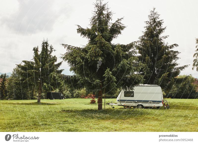 Caravan left among the pine trees on campsite exploring recreation house trip car transport grass ground field camping recreational equipment van life