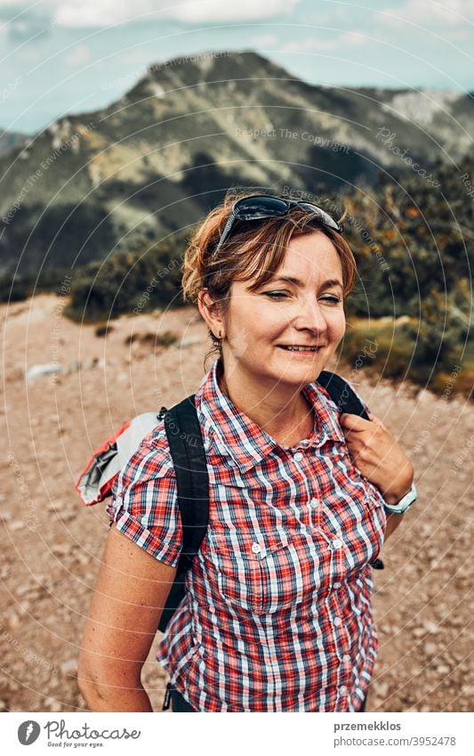 Smiling happy woman with backpack hiking in a mountains, actively spending summer vacation activity adventure female freedom fun green healthy joy leisure