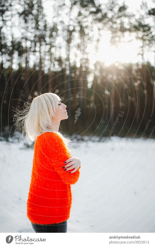 Cute girls have fun in the frozen park. Woman in a knitted sweater.the girl's hands froze winter portrait outdoor orange nature happy forest woman beautiful