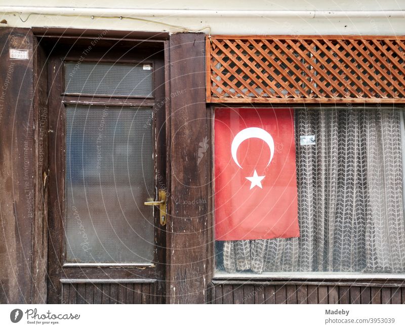 The Turkish flag in the window of a small old shop with curtain in Göynük in the province of Bolu in Turkey nationalism national pride national feeling