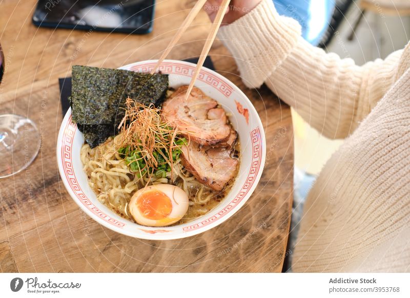 Woman eating traditional oriental ramen asian food noodle delicious bowl chopstick dish female pork egg meal tasty meat yummy woman cuisine lunch palatable