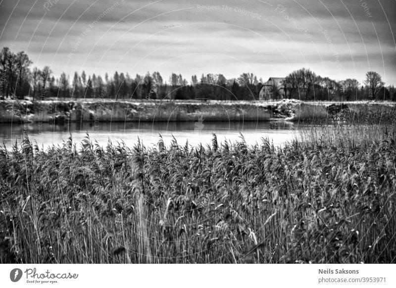 who lives on the other shore of river / over the reeds Latvia beautiful black and white building canal clouds coast coastal coastline country countryside day