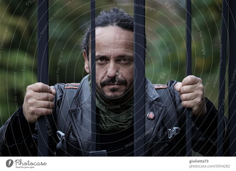 Angry man with fixed gaze behind wire fence, pursuer, stalker, scary, dangerous ostracized Emotions Leather jacket Man Adults 1 Human being 30 - 45 years