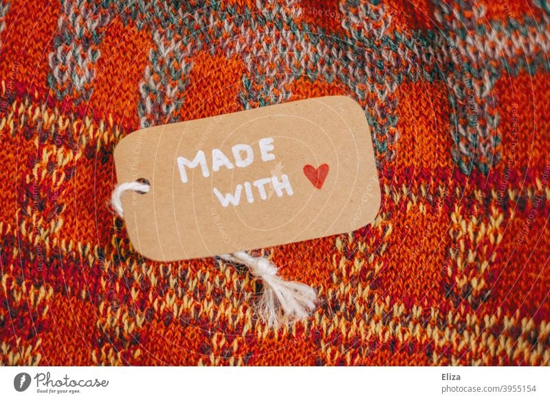 A label with the words "Made with Love" on a self-knitted garment Made with love crafted knitwear garments affectionately homespun shop locally Unique specimen
