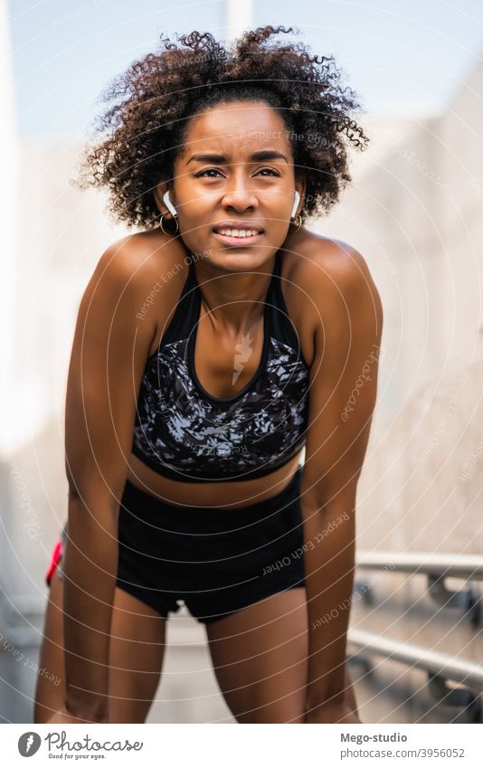 Athlete woman relaxing after work out outdoors. - a Royalty Free