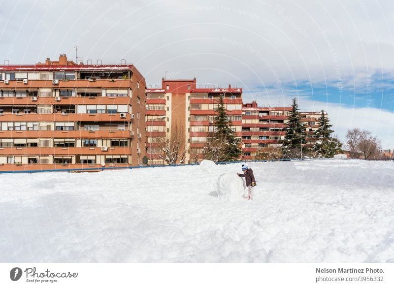 Little girl playing with a big snowball in the neighborhood. face december snowfall pretty baby nice travel 1 winter joy hat season people cheerful cute