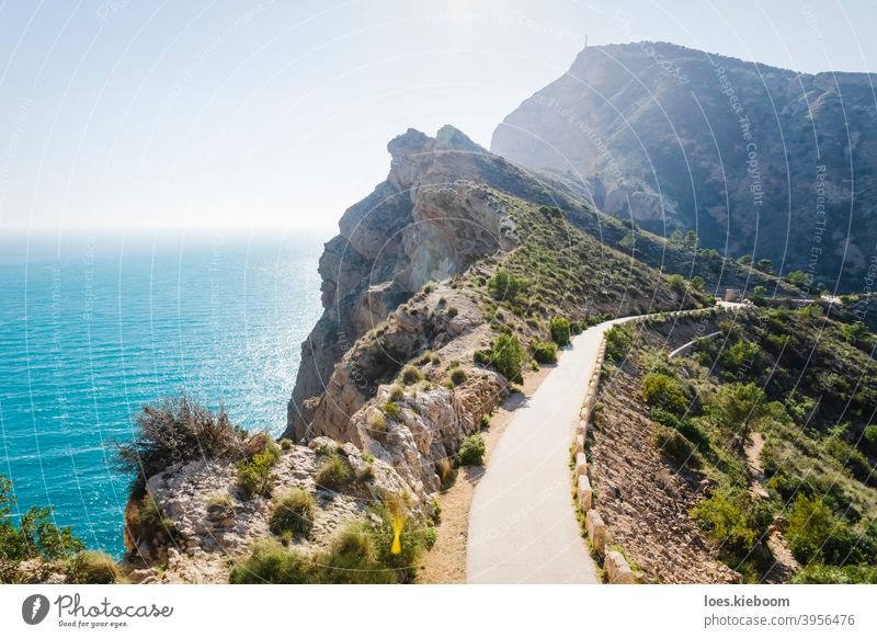 Scenic walking path along steep cliffs covered with bushes along the ocean in the natural park 'Serra Gelada' in Albir, Spain albir serra gelada mediterranean
