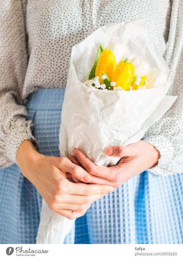 Woman holding bouquet of tulips. Woman's day flower bunch mother woman give spring easter hands floral white yellow lady march gift invitation greeting card
