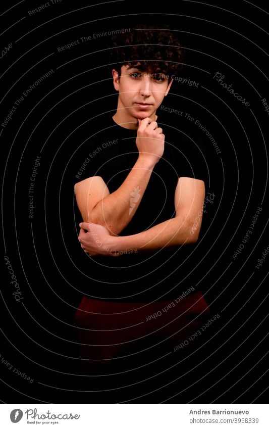 Attractive young man with curly hair posing on black studio background caucasian closeup thoughtful guy looking people short attractive beauty haircut fashion