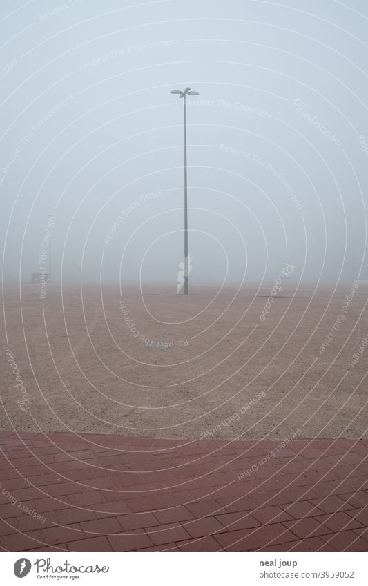 Street lamp on a wasteland disappearing in the fog; a parking lot Exterior shot Town urban FALLOW LAND Fallow land Industry surface Parking lot Fog Morning