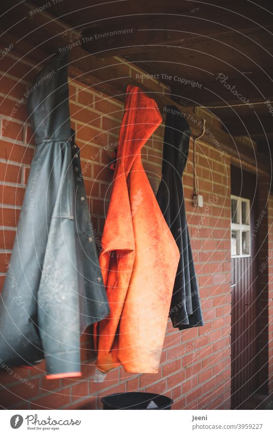 At the fisherman's in the small fishing village, the rain jackets hang next  to each other outside the door - a Royalty Free Stock Photo from Photocase