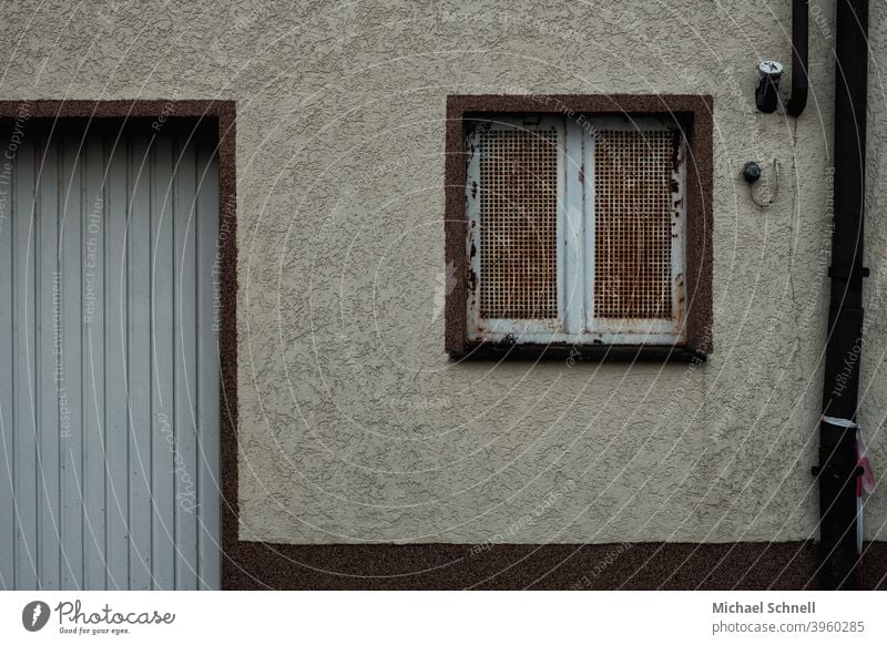 Old house wall with rusty lattice window, water pipe and garage house wall window Wall (building) Facade Exterior shot Deserted Wall (barrier) Building