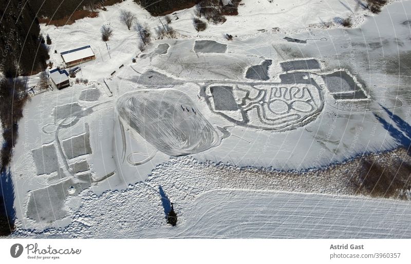 Aerial drone shot of frozen lake in winter with ice skaters Aerial photograph drone photo Lake Ice ice skating Winter sports Snow Landscape Bavaria Frozen