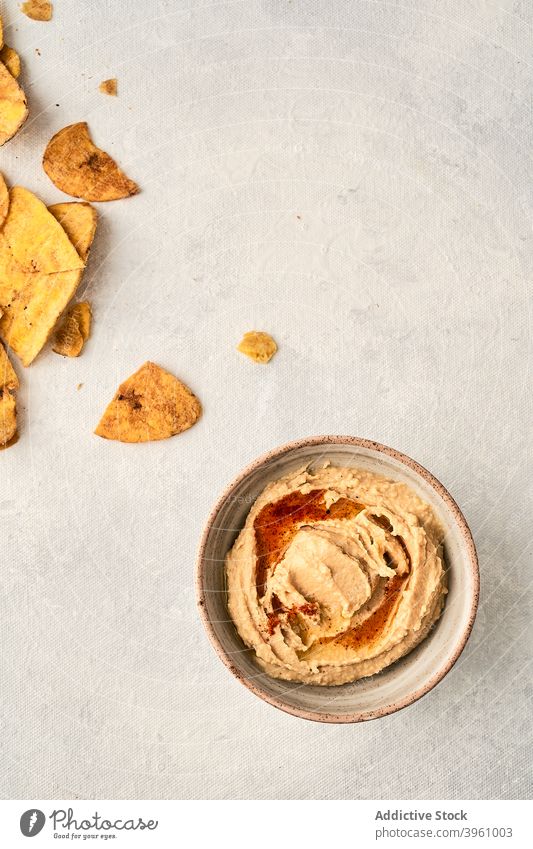 Hummus and potato chips on table hummus chickpea bowl dish mashed dip tasty delicious crispy food meal snack crunch fast food junk food cuisine appetizing