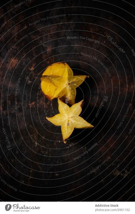 Top view of a carambola cut in half on rustic wooden background fruit food isolated yellow healthy slice fresh ripe diet orange tropical juicy organic star raw