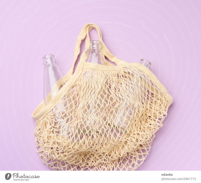 reusable textile shopping bag with empty bottles on a purple background glass grocery handbag lifestyle market mesh bag natural nobody object organic recycle