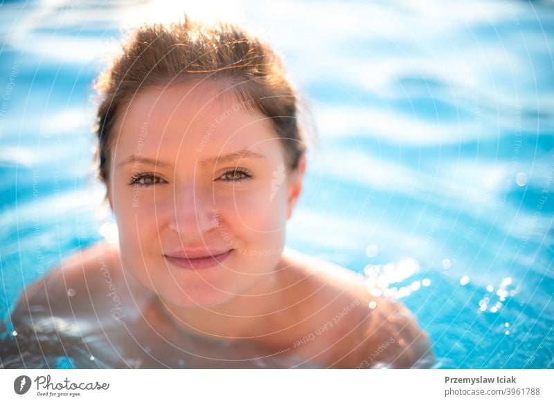 Young woman portrait in swimming pool. fashion candid spa water looking person girl authentic eyes summer face sun bikini caucasian beautiful lifestyle healthy