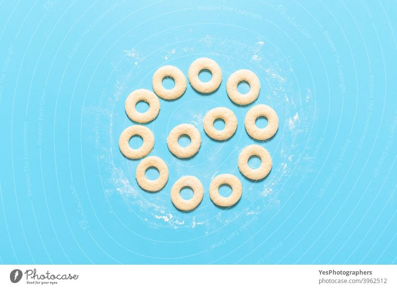 Cooking donuts process. Making American doughnuts. Homemade sweet dough top view aligned american baking blue background breakfast cake circle shape