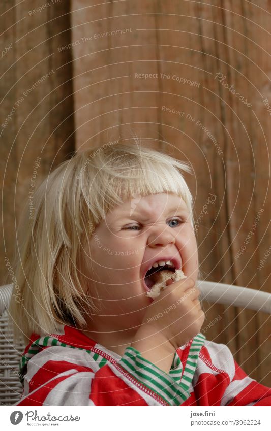 Mh delicious bread Girl cute Joy Grimace Impish fringe hairstyle portrait Blonde little girl Child Infancy Cute Brash Eating To enjoy excited spellbound