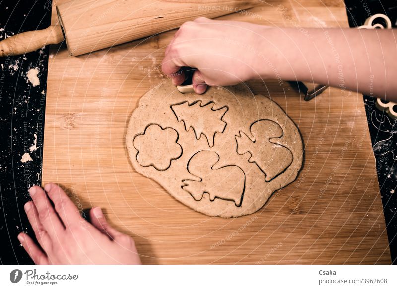 Top view of woman's hands making gingerbread preparing top homemade cookie sweet food raw dough rolling pin dessert pastry christmas cutter traditional