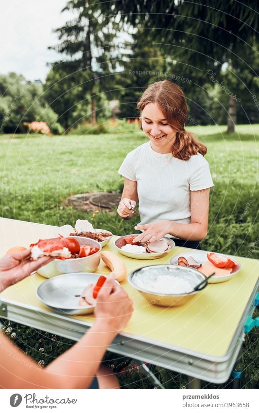 Family having breakfast outdoors on camping during summer vacation authentic real banana cooked meat slow living outdoor table setting outdoor activities