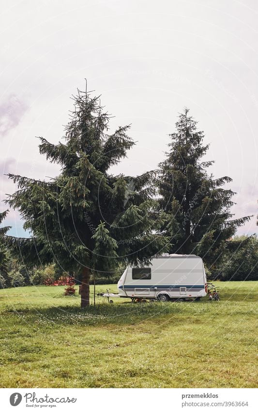 Caravan left among the pine trees on campsite exploring recreation house trip car transport grass ground field camping recreational equipment van life