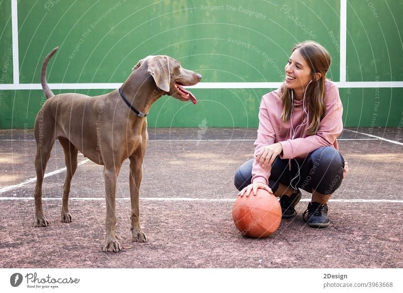 Young woman holding ball posing with her dog sport person basketball female girl player pet exercise young healthy lifestyle fit game body happy pretty