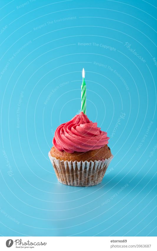 Pink birthday cupcake on blue background bakery buttercream candle celebrate concept creamy decorated delicious dessert food frosting gourmet holiday muffin