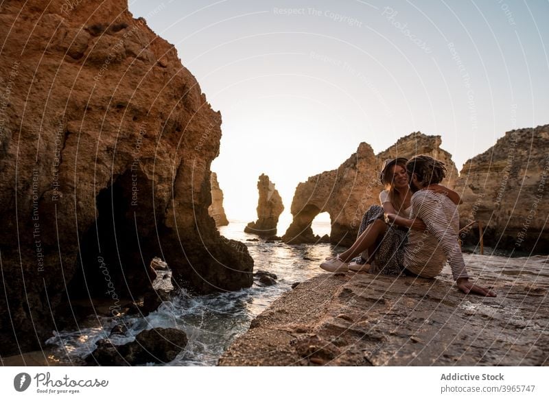Loving couple hugging near sea and cliffs sunset date shore water man woman algarve portugal rough together love relationship ocean coast nature casual travel