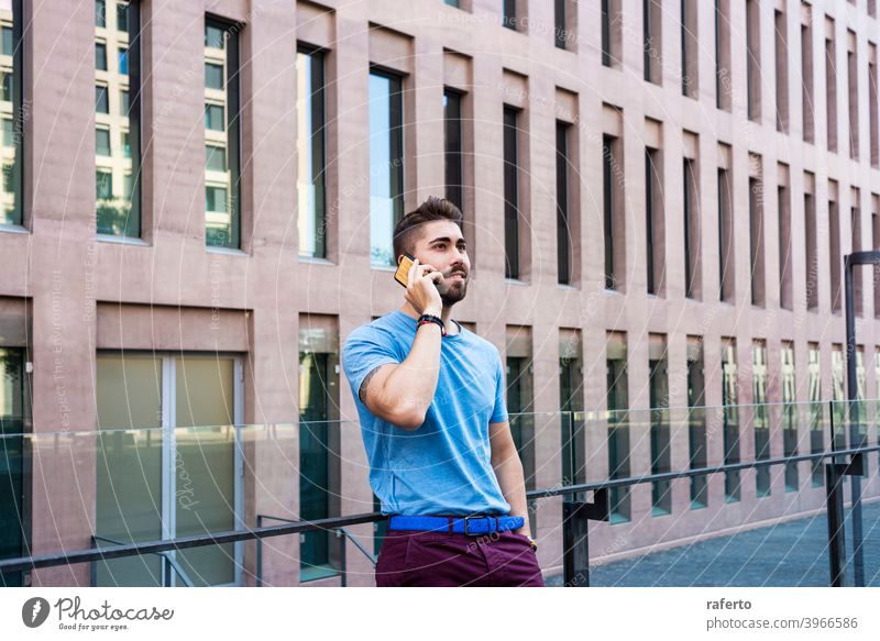 Portrait of cheerful modern businessman speaking by phone and smiling while standing outdoors building talking mobile city male photogenic adult people street