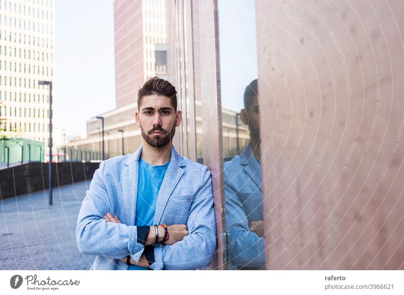 Young bearded man with crossed arms, model of fashion, in urban background wearing casual clothes cool style portrait guy 1 photogenic stylish modern adult