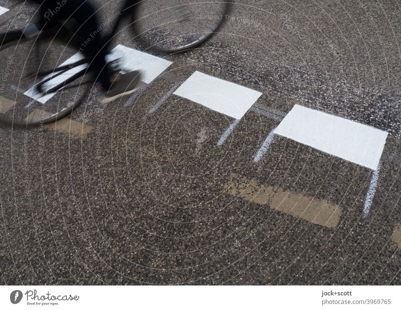 Cyclist rides over freshly painted road markings Lane markings Traffic infrastructure Asphalt Street Road sign New Traffic cone Dashed line Mobility cyclist