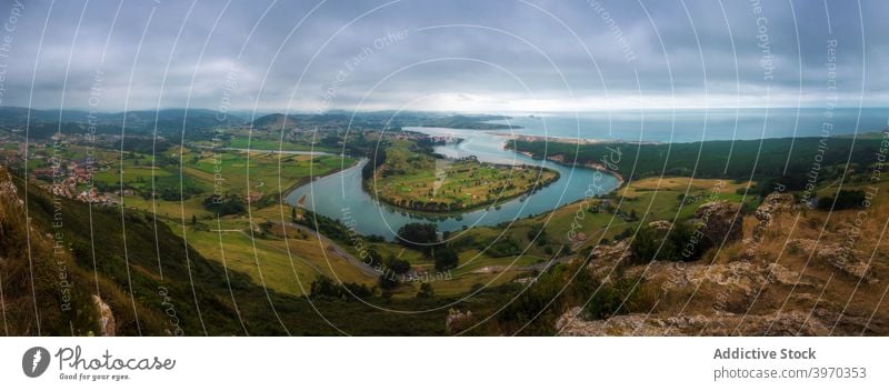 Green coastline and cape landscape under cloudy sky sea peninsula overcast dramatic ocean shore seaside scenery picturesque spain cabo mayor santander travel