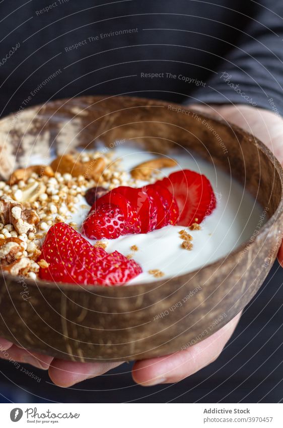 Crop person with breakfast bowl super food healthy morning delicious yogurt berry granola nut nutrition nutrient strawberry sweet cereal muesli fresh meal tasty