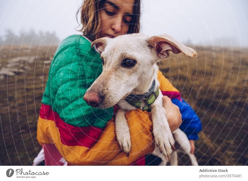 Woman kissing dog in nature woman owner love friendship animal together tender female adorable white stroll pet pedigree obedient canine companion domestic