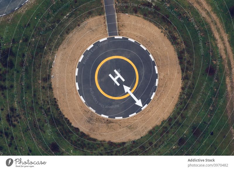 Modern round helipad in green suburbs road curve mountain landscape highland picturesque terrain nature scenery scenic environment hill breathtaking valley