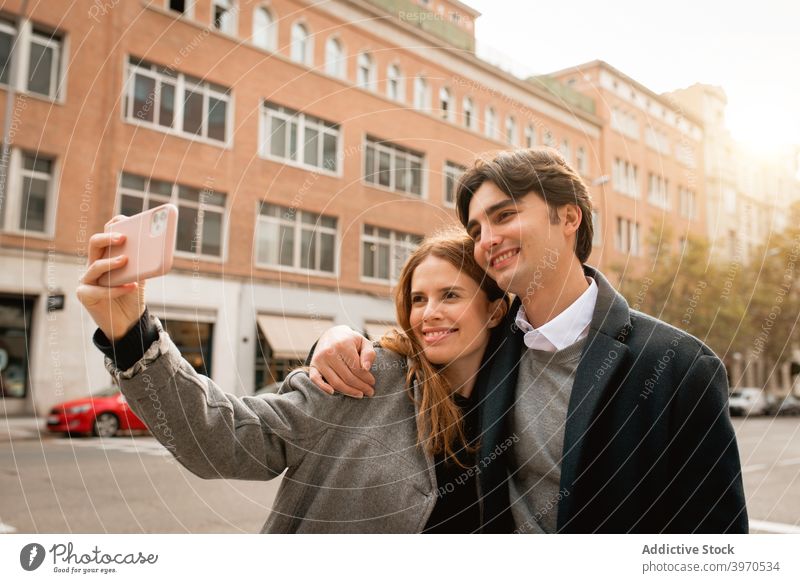 Loving young couple taking selfie on street love together happy smartphone relationship embrace girlfriend boyfriend cheerful lifestyle romantic affection date