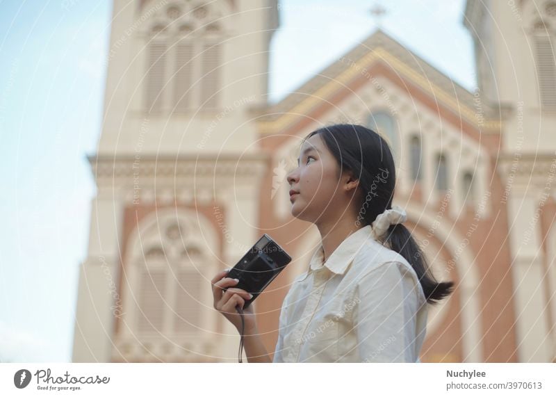 Young asian millennial teen girl using camera during traveling in the street and church background, teenager and travel concept attractive beautiful casual