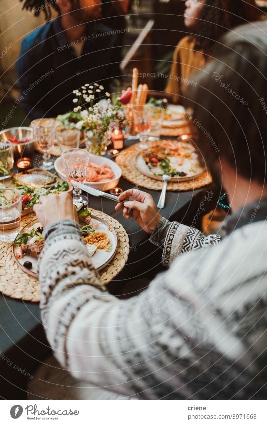 Group of friends eating food and having fun at dinner party together Adult Candid Outdoor Young Adult alcohol backyard bread celebrating chatting diversity