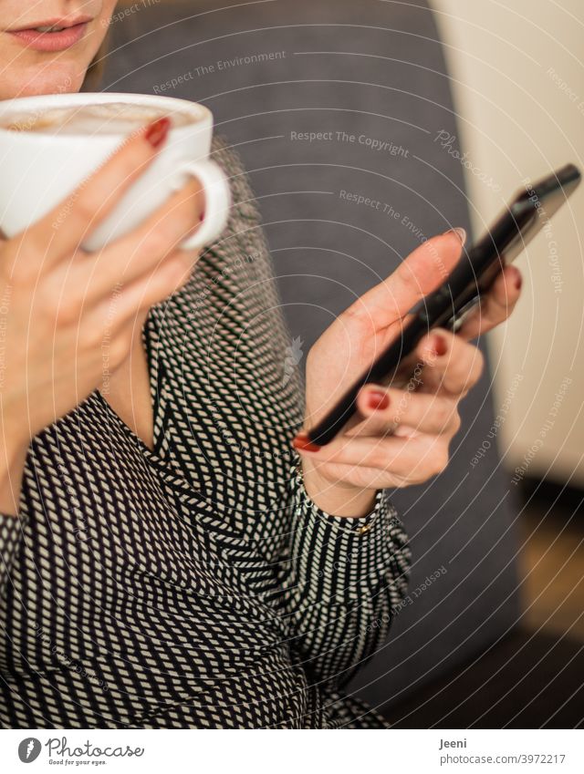 Young pretty woman sitting in a cafe, drinking a cappuccino and looking at her smartphone youthful Woman Looking Email Telephone Surfing Internet Hand hands