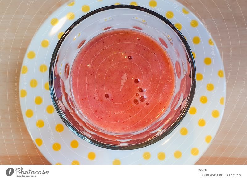Fresh red fruit smoothie in a glass on a white plate with yellow dots defenses drink fitness fresh fruity healthy nature organic food regional regional products