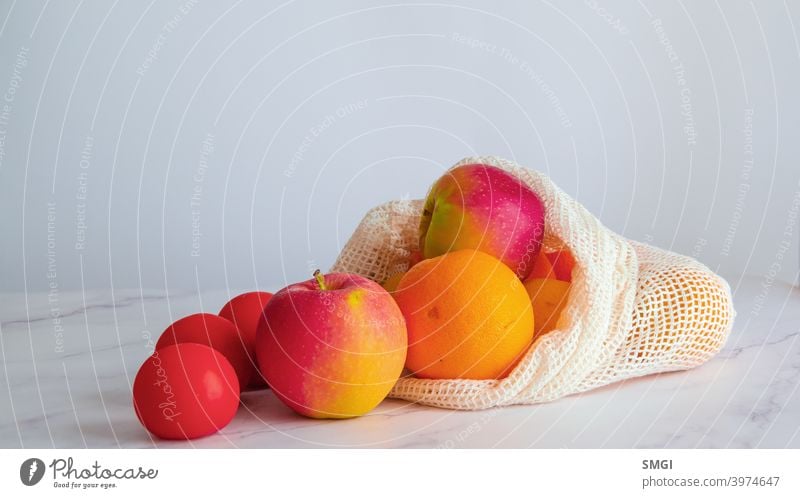 Different fruits and vegetables on a white table, inside a cloth bag. Concept of sustainable shopping and purchasing without plastics. Copy Space background eco