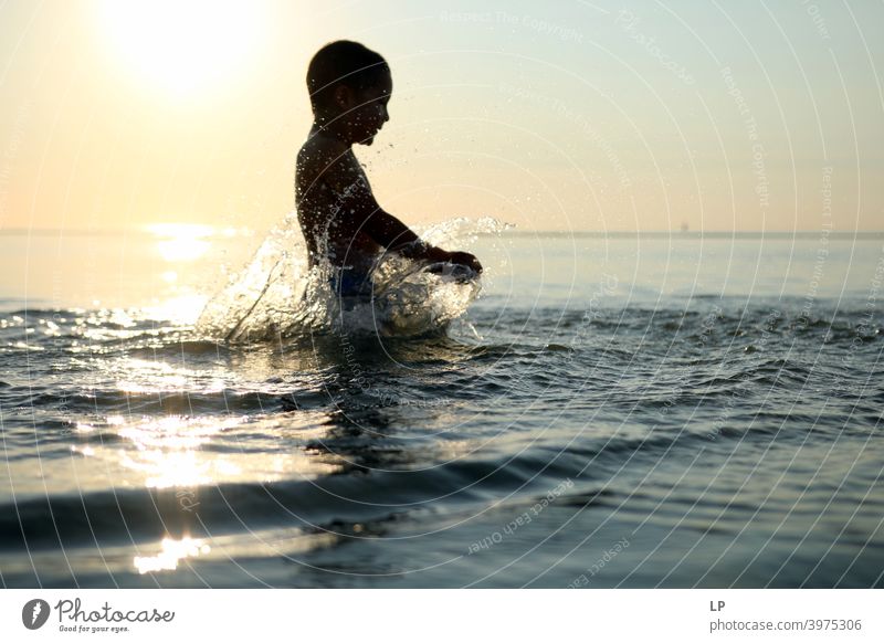 happy child in the ocean at sunset playing with water Faith & Religion background Forward Arm Hand Contentment Dance Posture Vacation & Travel Twilight