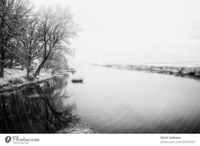 calm water in Latvian winter / river near my house / the day when ice forming on water / sunrise over land Autumn background cold color December February forest