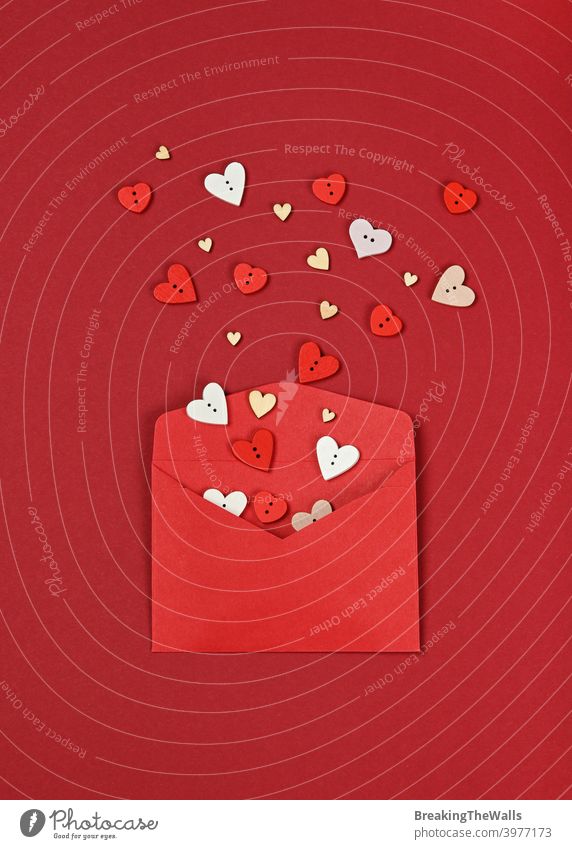 White hearts out of red paper envelope Love shape wooden button maroon white background closeup copy space holiday festive message symbol present feelings