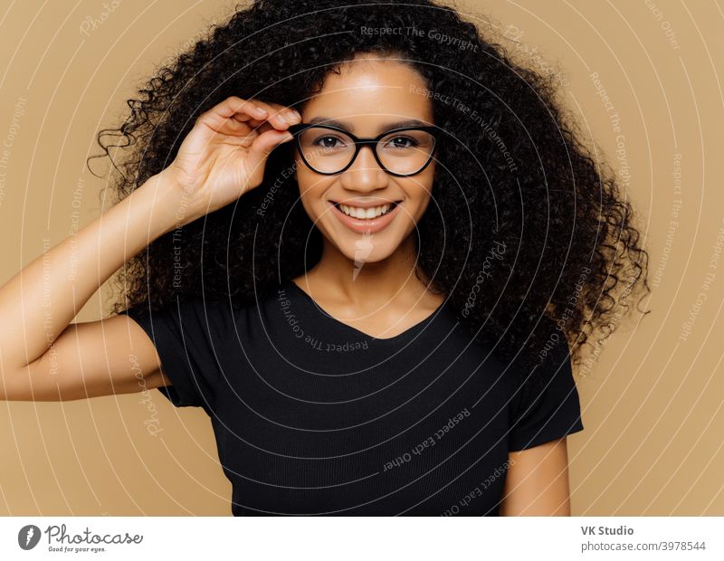 Positive curly haired businesswoman wears spectacles, formal wear, has  bushy hairstyle, being in good mood after successful day at work, poses  against violet background. Monochrome. Happy director Yoga Mat by VK Studio  -