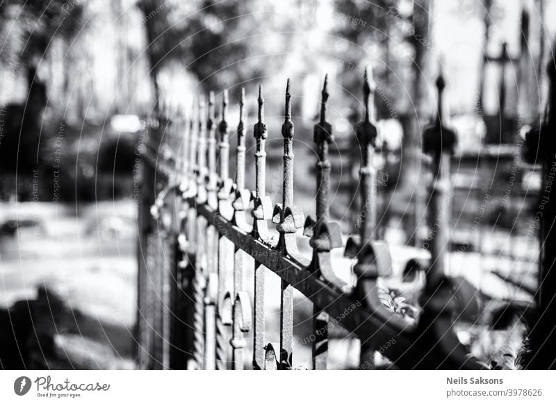 Hundred years old cast iron fence around family grave in some country cemetery in Latvia. Perspective made of many equal art masterpieces. ancient antique