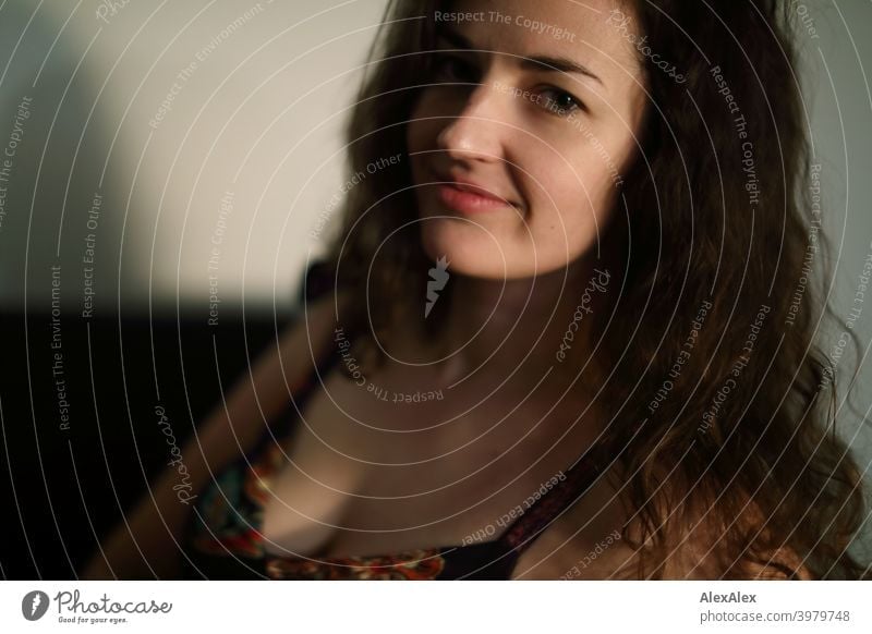 Portrait of a young brunette long haired woman lying upside down on a ...