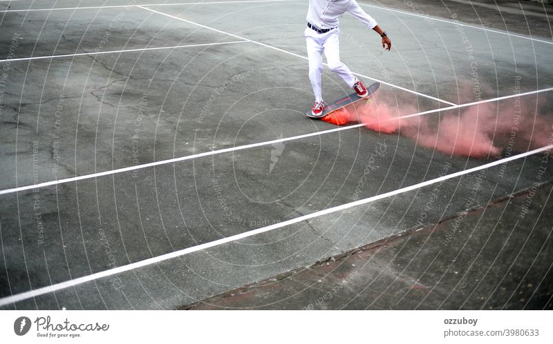 Skateboarder playing at tennis court with pink smoke on skateboard skateboarding Pink Smoke urban sport skater young lifestyle Tennis court skateboarder youth